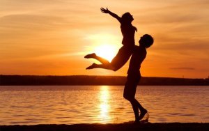 happy-couple-on-the-beach-at-sunset-600x375